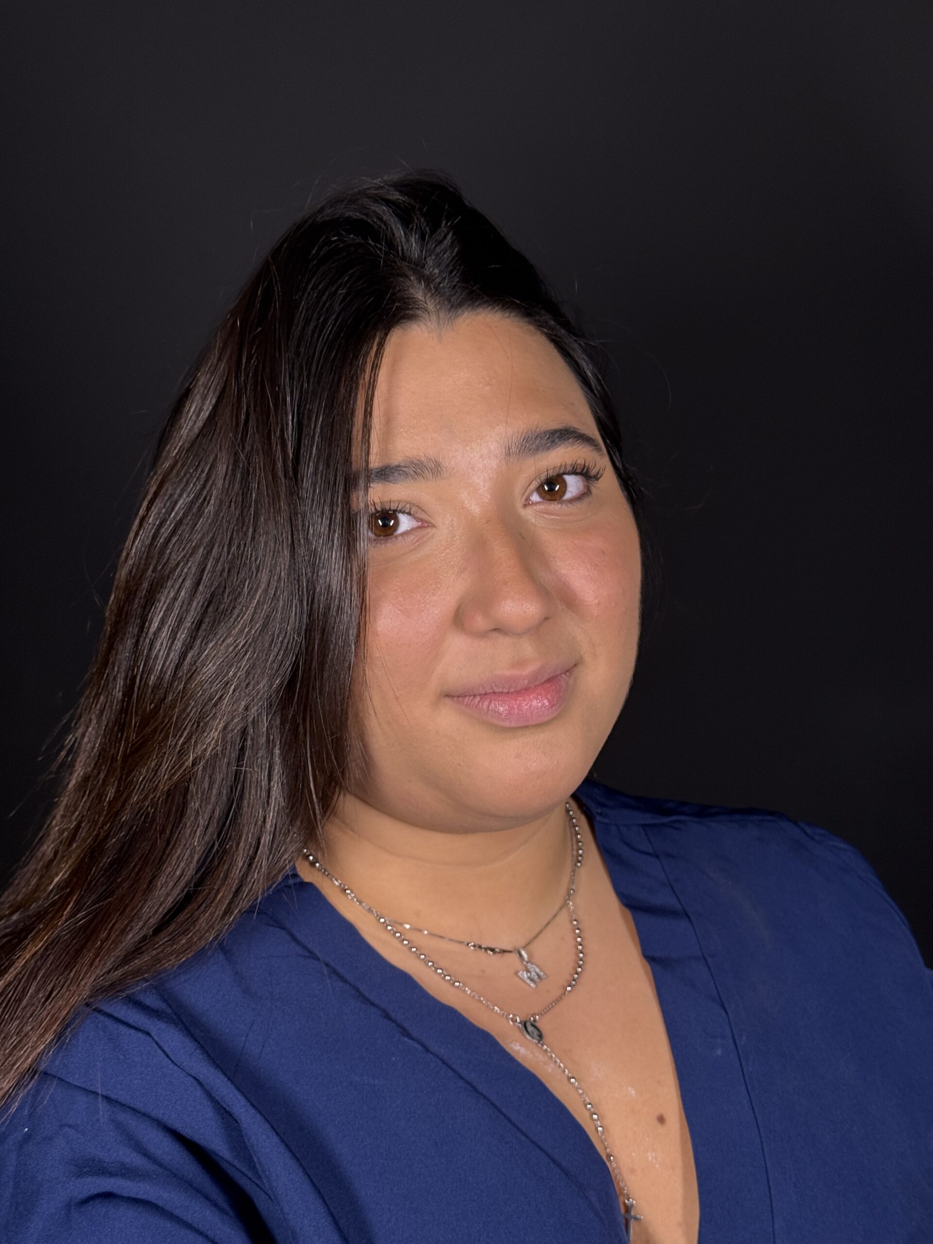 Ritratto di Francesca, assistente alla poltrona in divisa, su sfondo nero nello Studio Dentistico Pigno a Torre del Greco